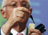 European komisarz ds. przemysłu i przedsiębiorczości Guenter Verheugen z ładowarką telefoniczną na konferencji w Brukseli, 29 czerwca, 2009.